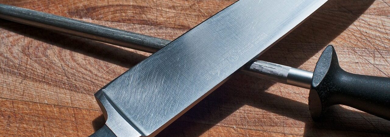 Kochmesser und Wetzstab, einsatzbereit auf einem Holzschneidebrett.