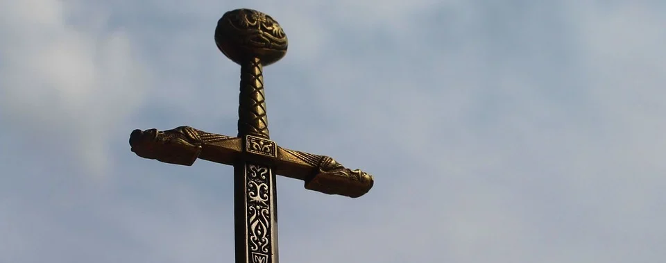 Nahaufnahme eines dekorativen Schwertgriffes vor dem Hintergrund eines wolkig-blauen Himmels.