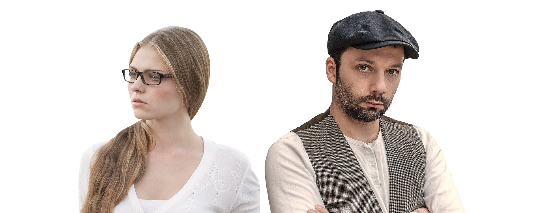 Eine Frau mit Brille und langen Haaren und ein bärtiger Mann mit Mütze stehen nebeneinander, beide schauen ernst.